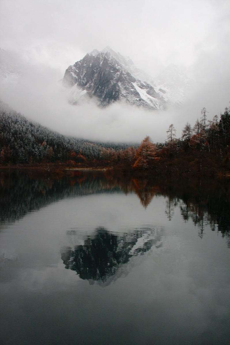 A misty mountain over a still lake, as desktop wallpaper